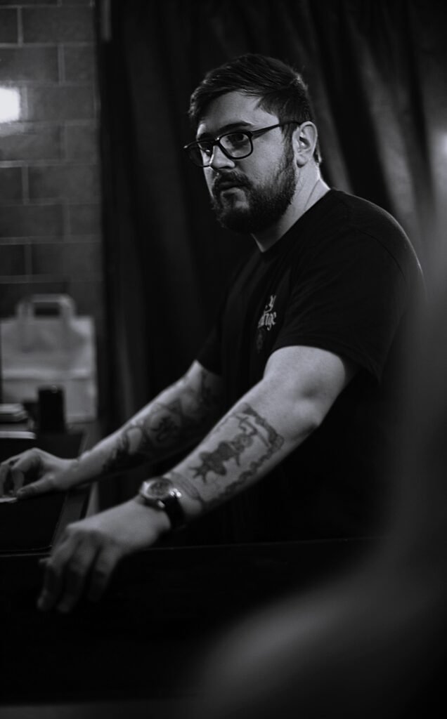Daniel Sutton performing at a table, black and white portrait